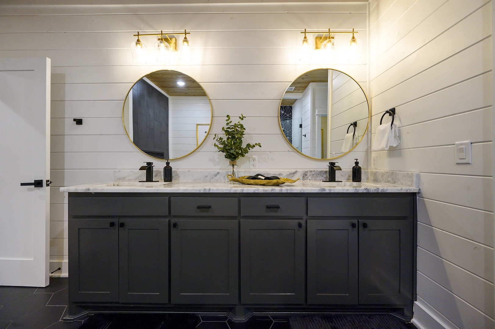 Step into your spa-like bathroom with dual vanities, golden mirrors, and marble countertops—perfect for sharing morning routines in style.