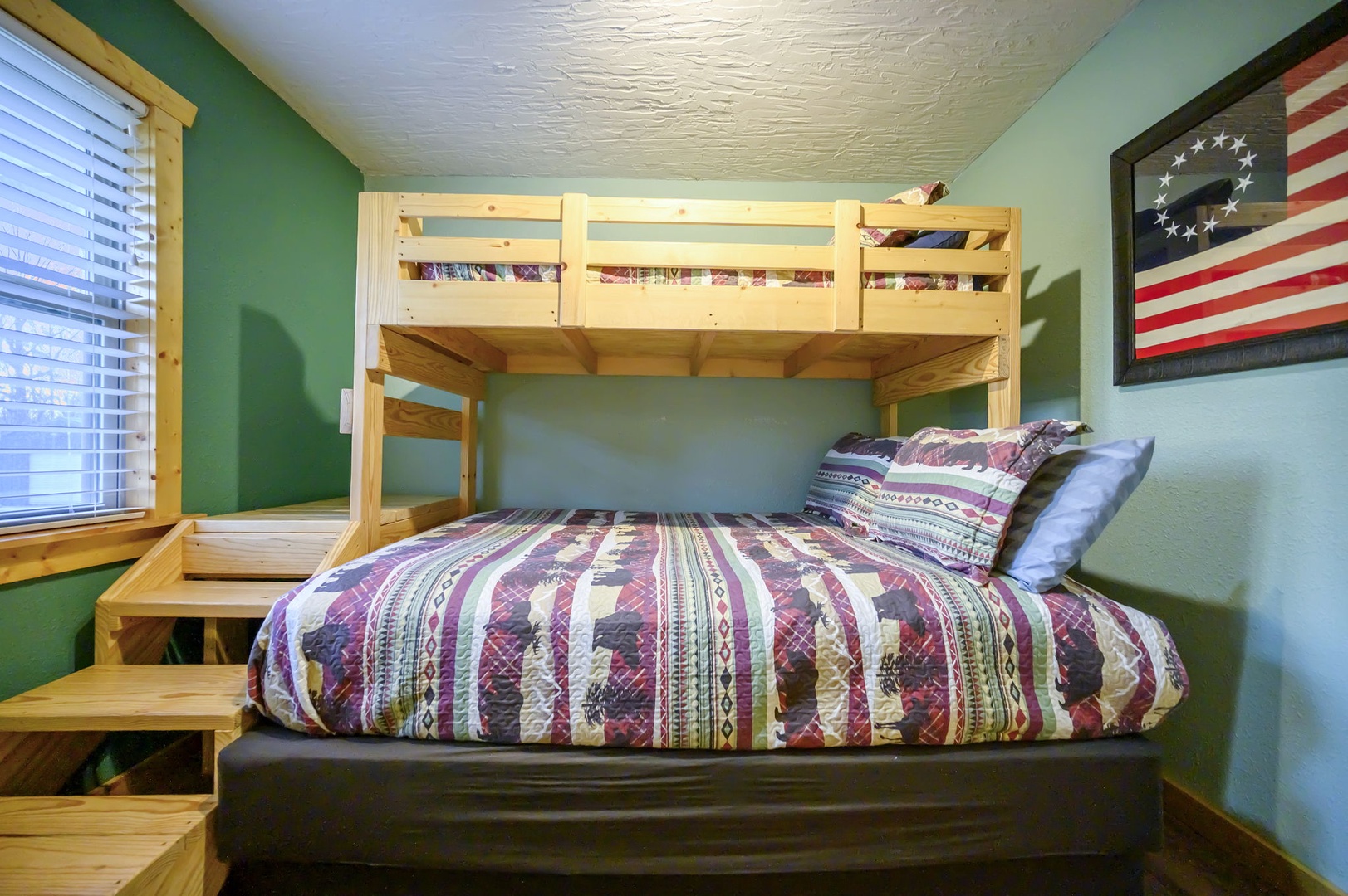 Rest comfortably in this cozy bunk bed setup with vibrant quilted bedding and rustic wooden stairs leading to your upper retreat.