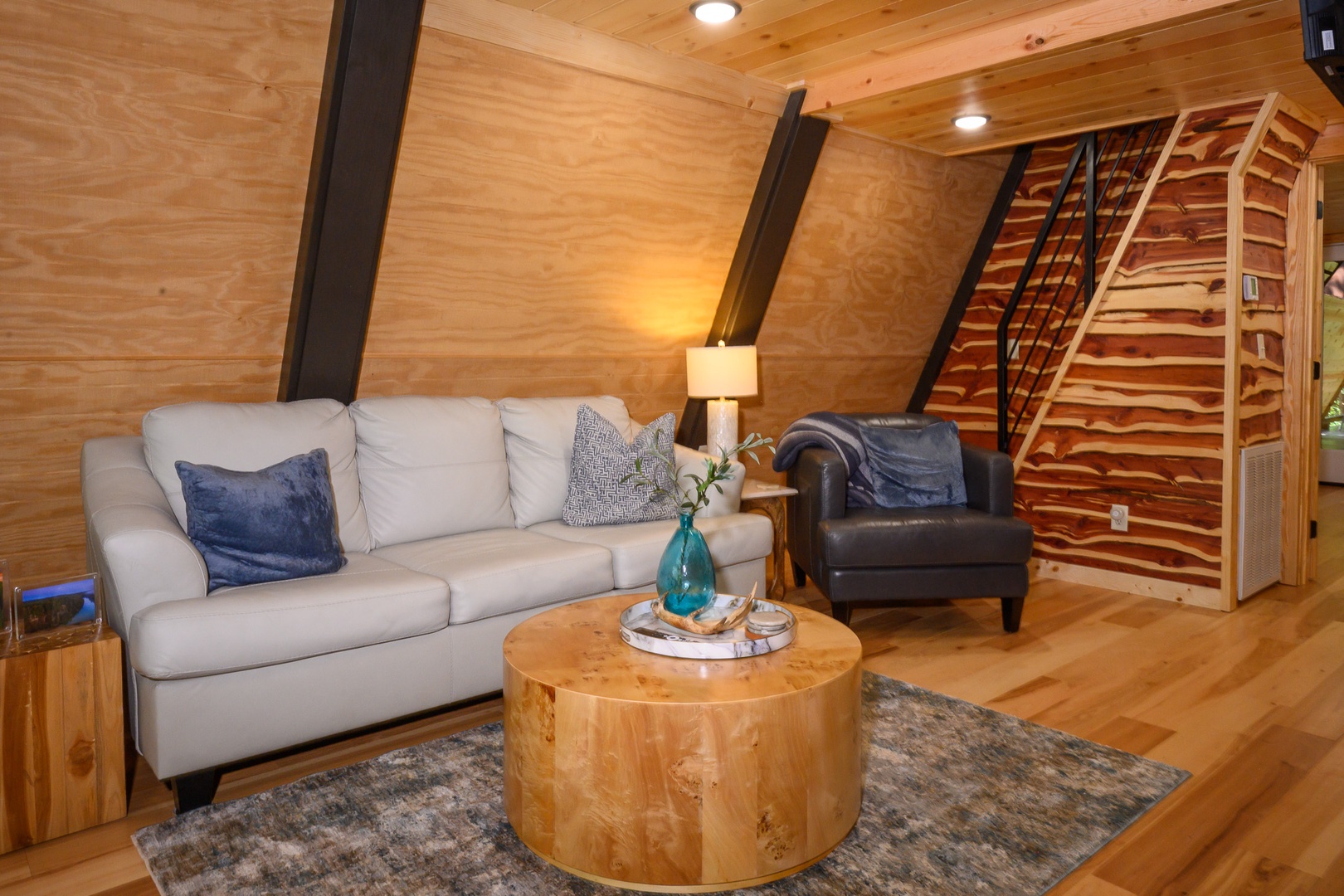 Unwind in your cozy living area with warm wood finishes and a plush sofa—perfect for relaxing after a day of adventure.