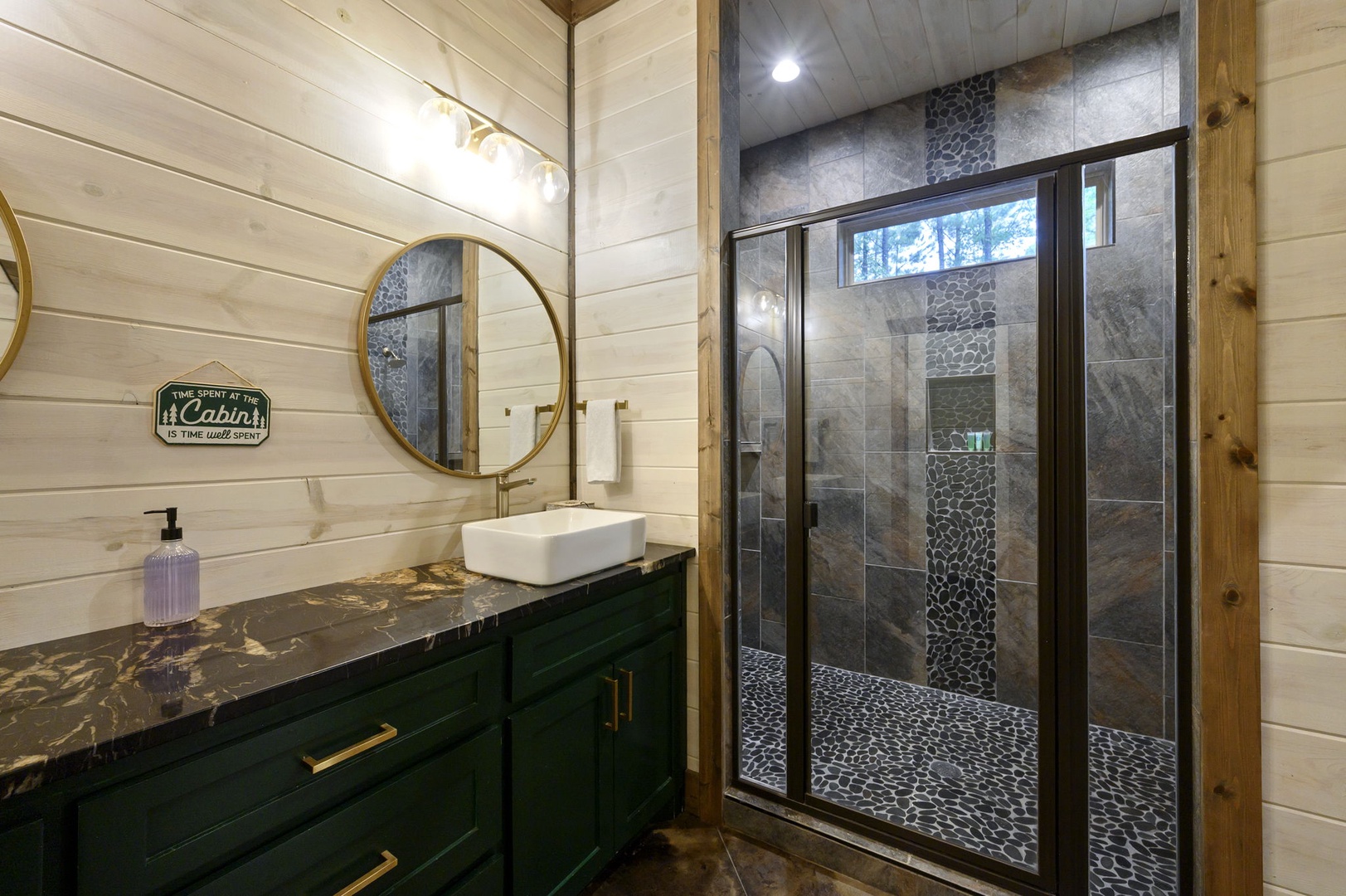 Step into your rustic-elegant bathroom featuring a spacious stone-tiled shower, sleek vessel sink with rich marble countertop, and warm white shiplap walls that blend modern comfort with cabin charm.