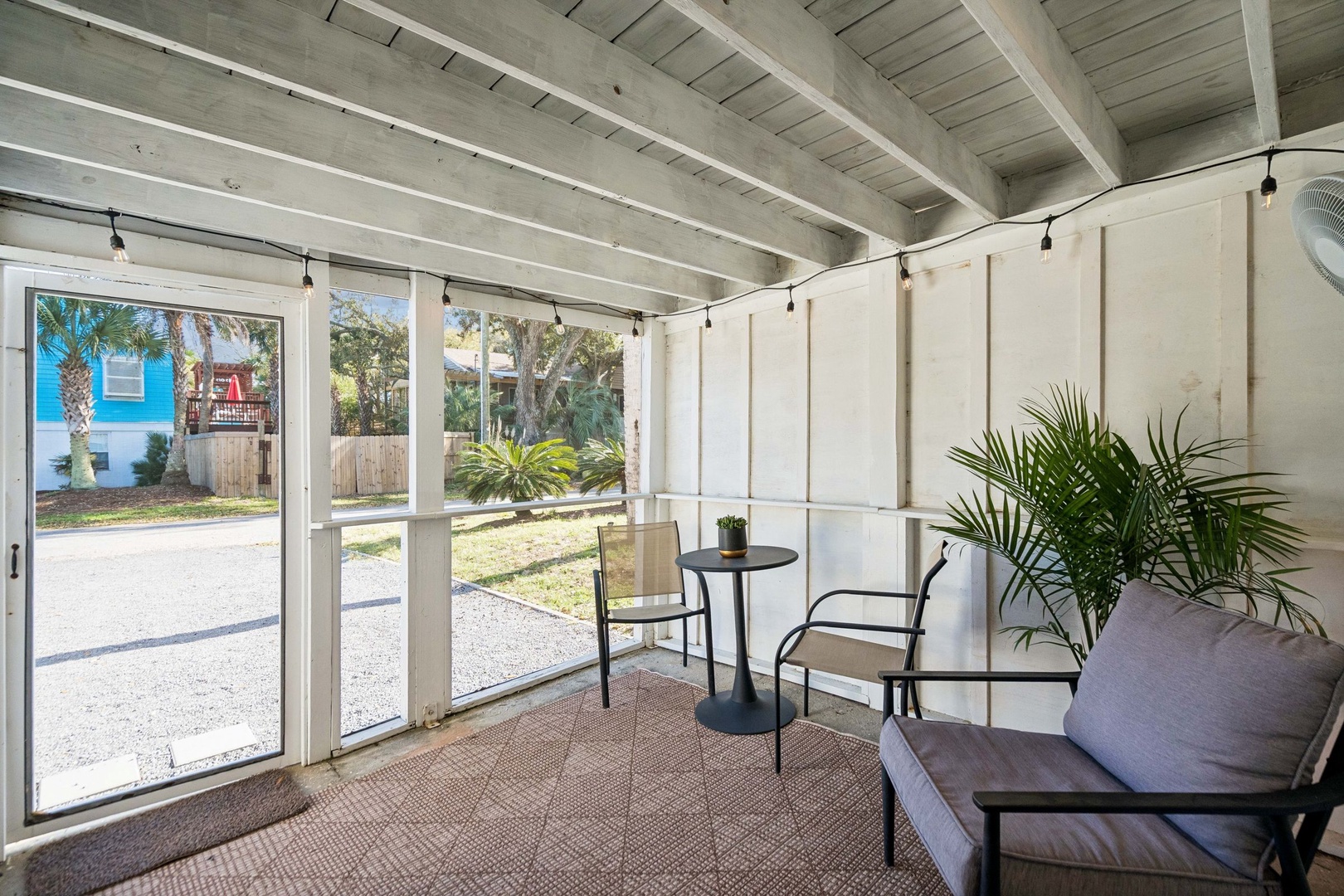 Unwind in your private screened porch with comfortable seating and tropical views, perfect for morning coffee or evening relaxation.
