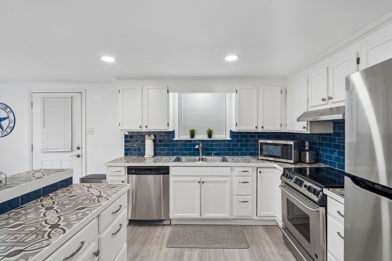Your gourmet kitchen awaits with stainless steel appliances, stunning blue subway tile backsplash, and granite counters perfect for cooking memorable meals.