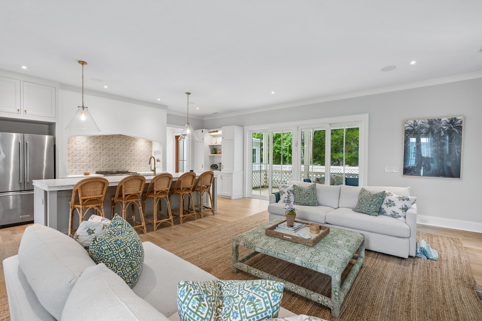 Gather around the expansive kitchen island for morning coffee or evening appetizers, then relax in the airy living area where natural light pours in through French doors leading to your private outdoor retreat.