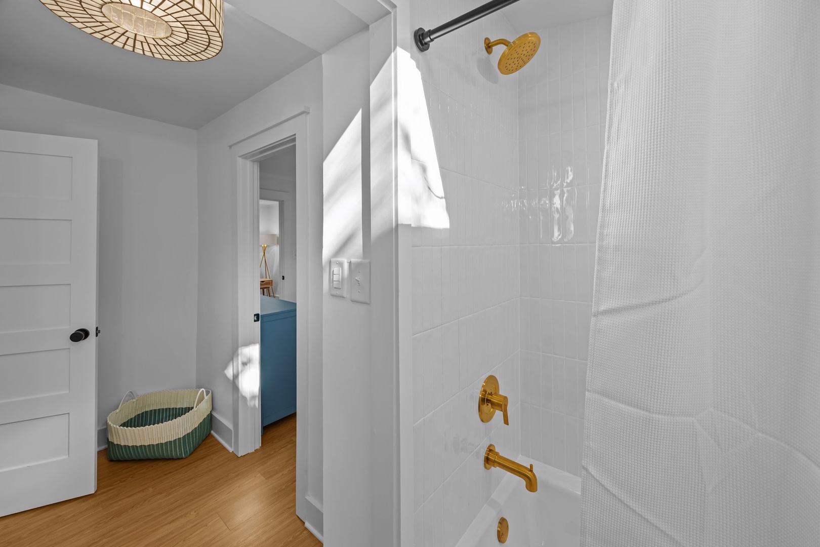 Step into your bright, contemporary bathroom featuring elegant gold fixtures and a spacious shower with beautiful natural light streaming in.