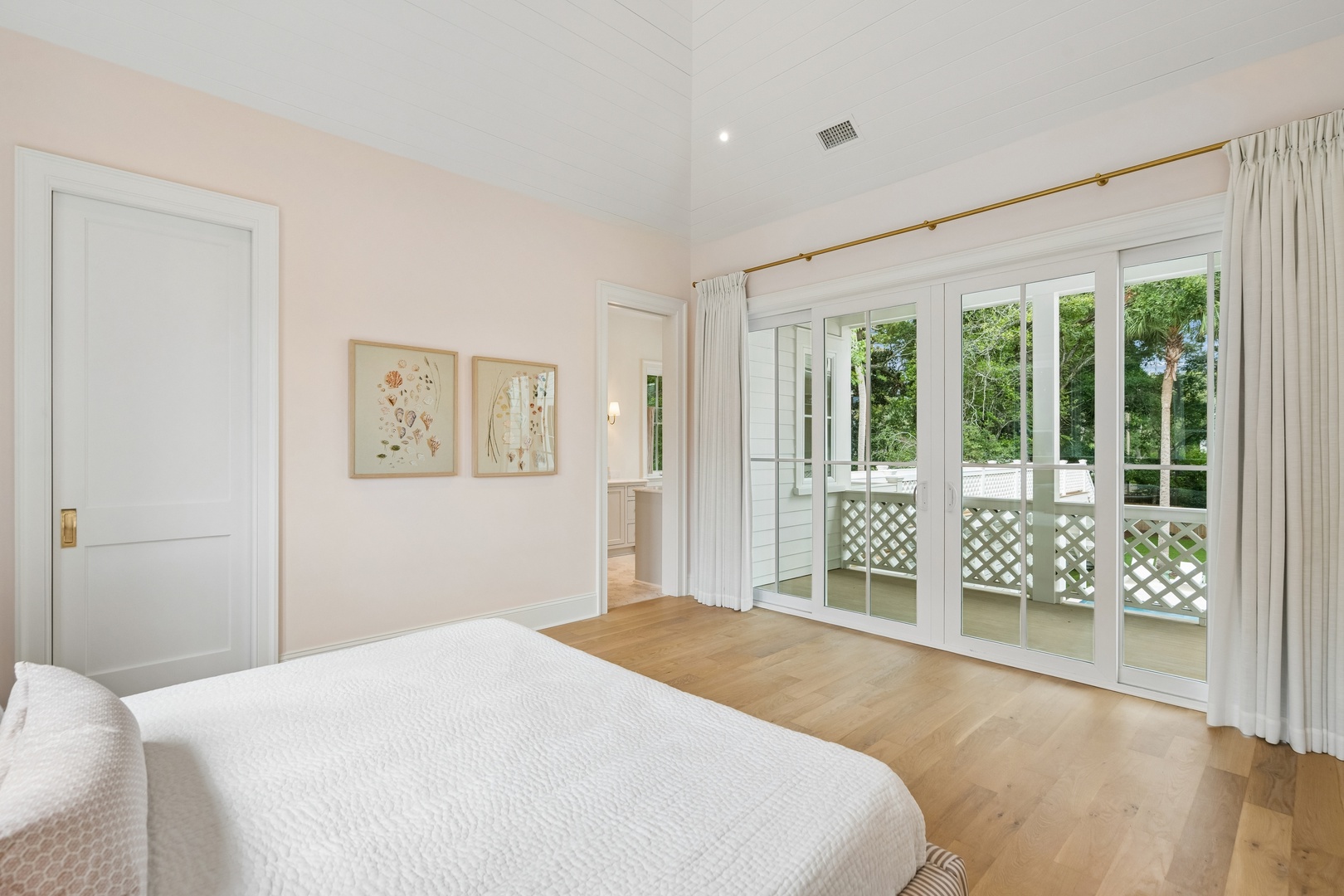 Step into your serene retreat where soft white linens and warm hardwood floors invite you to unwind. Floor-to-ceiling glass doors open to your private balcony overlooking lush greenery.