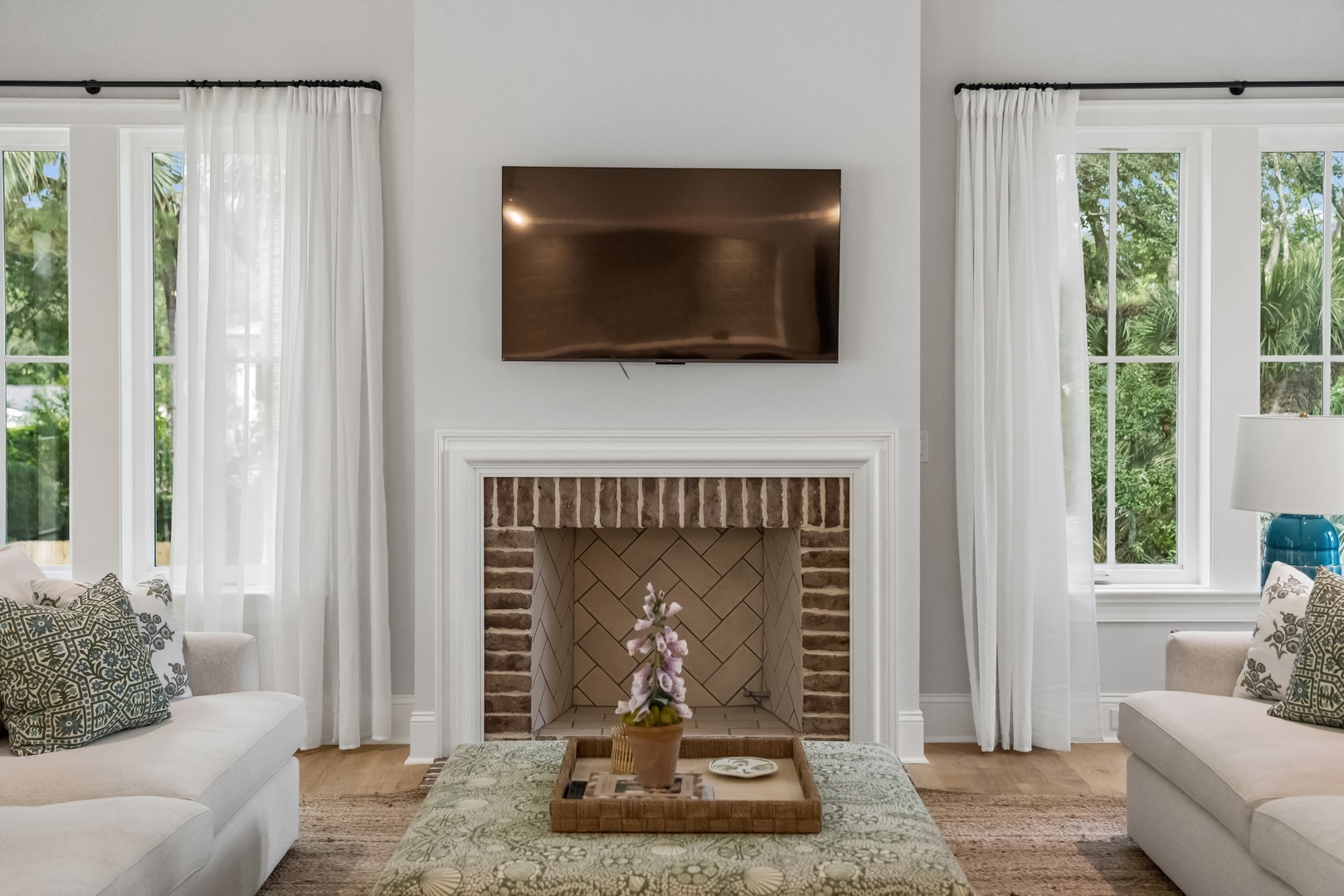 Sink into plush sofas by the warmth of the fireplace, with natural light streaming through large windows framing lush garden views. Your perfect space to unwind and reconnect.