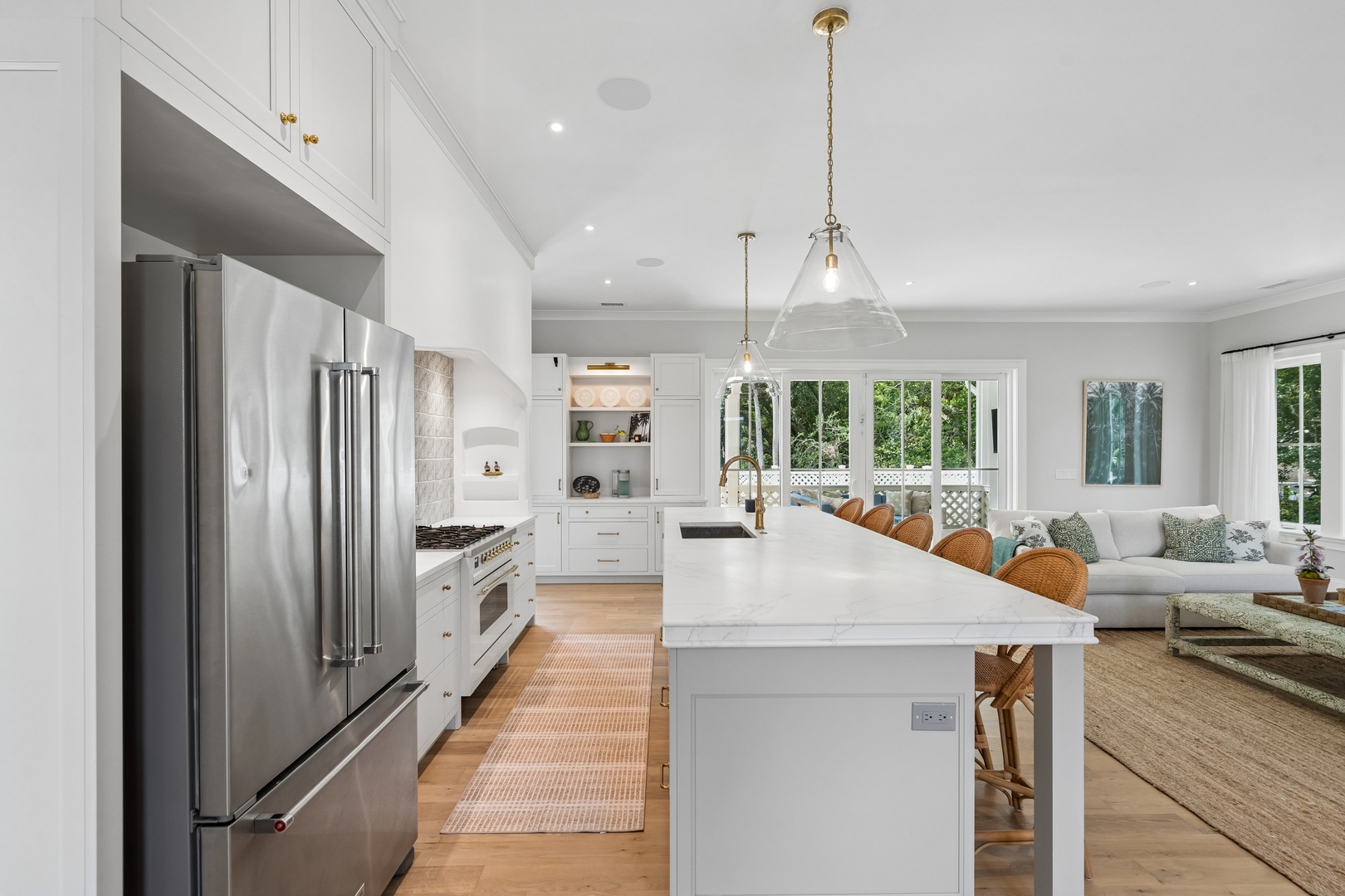 Sunlight floods your open-plan living space, where a gleaming kitchen island invites you to gather with loved ones. Elegant pendant lights and garden views create a warm, welcoming retreat.