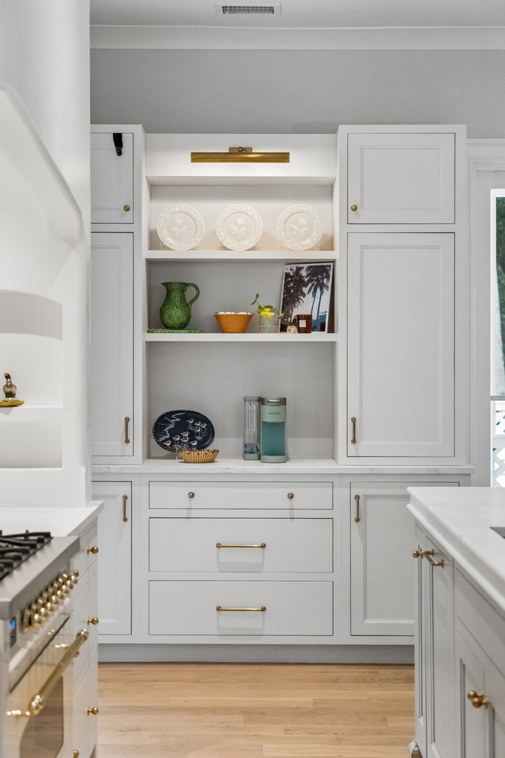 Step into your gourmet kitchen where elegant cabinetry and brass accents create a warm, inviting space for preparing memorable meals together.