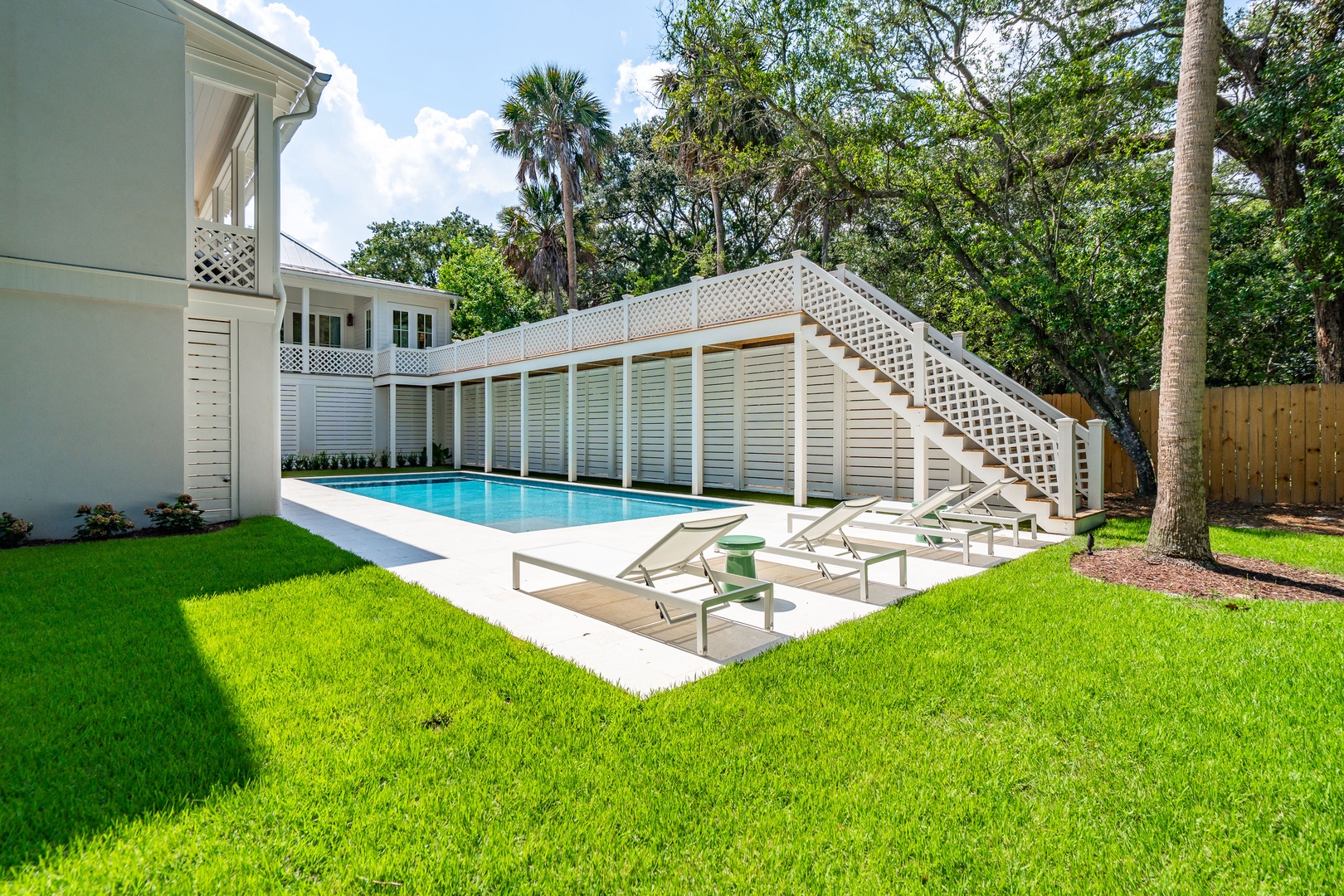 This pristine property features a beautifully maintained pool nestled among lush greenery and mature palm trees, offering the perfect setting for outdoor relaxation and entertaining.