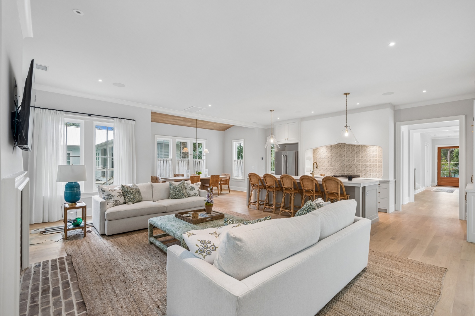 Bright open-concept living space with soft neutral tones and natural light. Perfect for gathering with loved ones at the breakfast bar or sinking into plush seating.