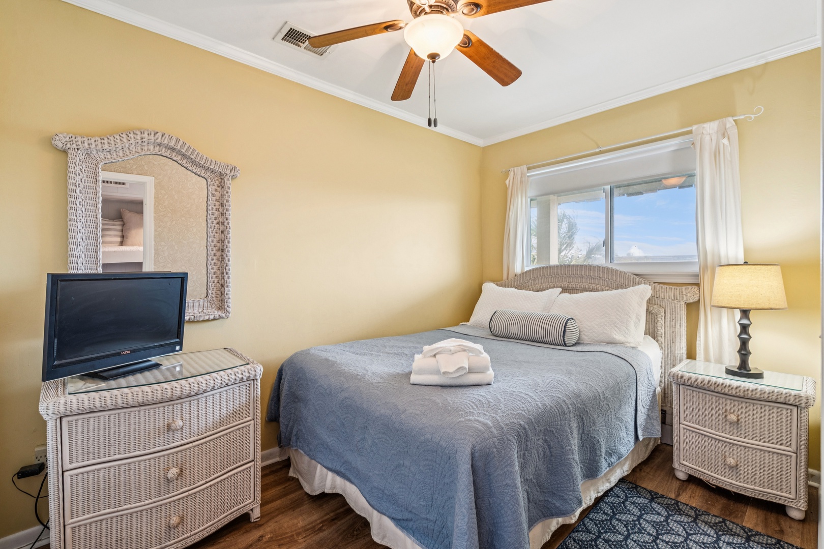 Sink into this cozy bedroom where coastal charm meets comfort. The ceiling fan keeps you cool while you rest.