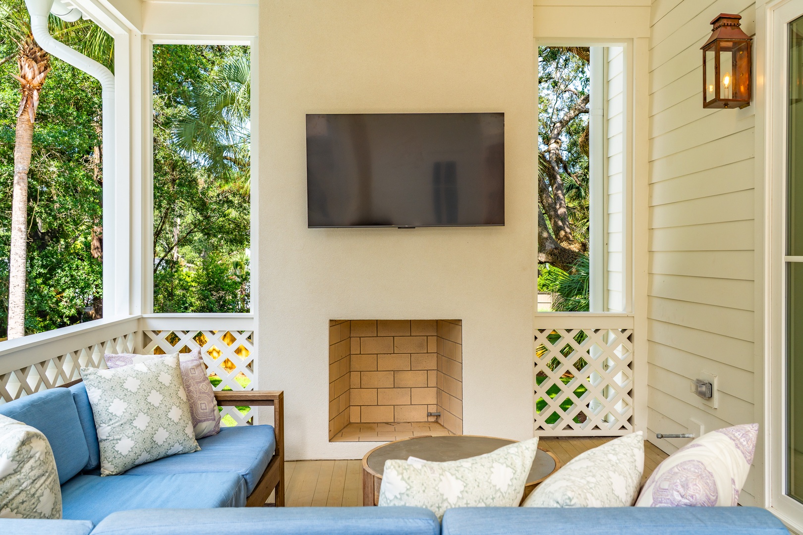 Unwind on your private covered patio with soft seating, an ambient fireplace, and tropical garden views framing your peaceful retreat.