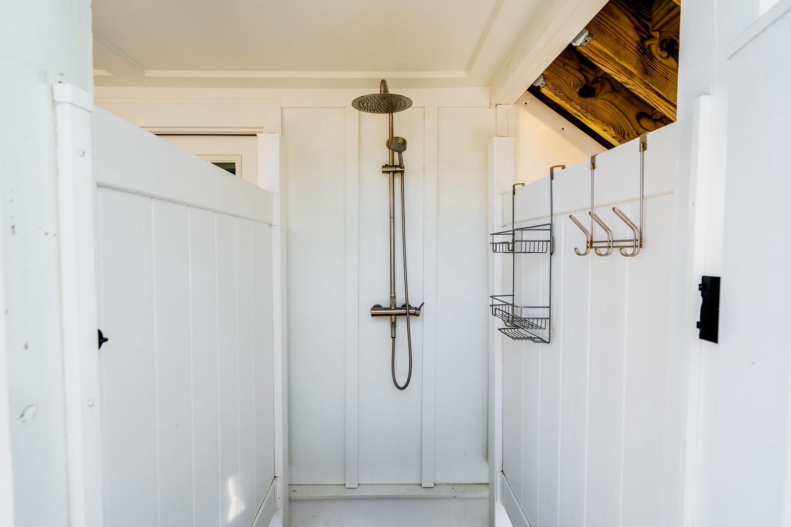 Step into your bright, modern shower sanctuary with rainfall head and convenient storage baskets for all your toiletries.