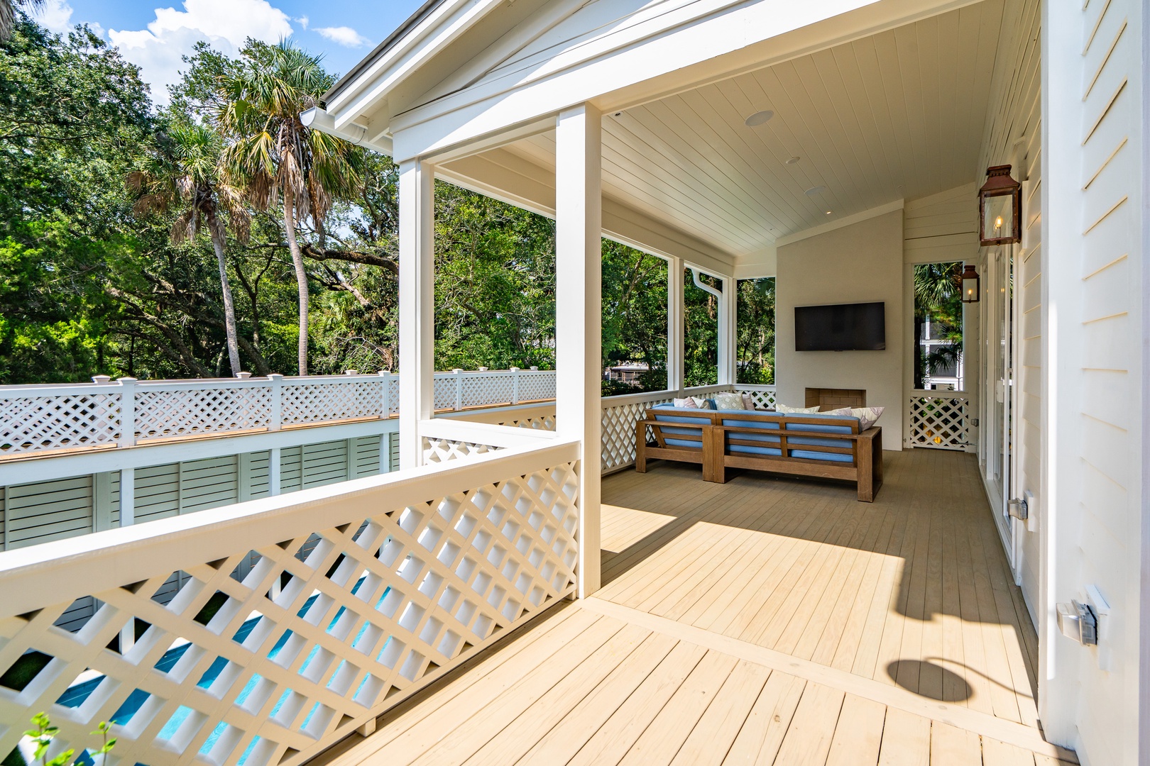 Step out onto this beautifully designed covered porch where you can unwind on the comfortable seating, take in the lush garden views, and enjoy peaceful afternoons surrounded by coastal charm and natural beauty.