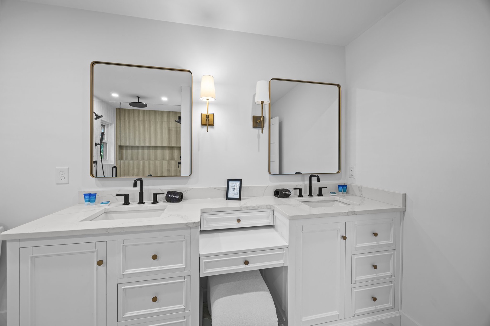 Prepare for your day in this elegant dual-vanity bathroom, featuring marble countertops, brass fixtures, and thoughtful lighting that creates your perfect morning routine.
