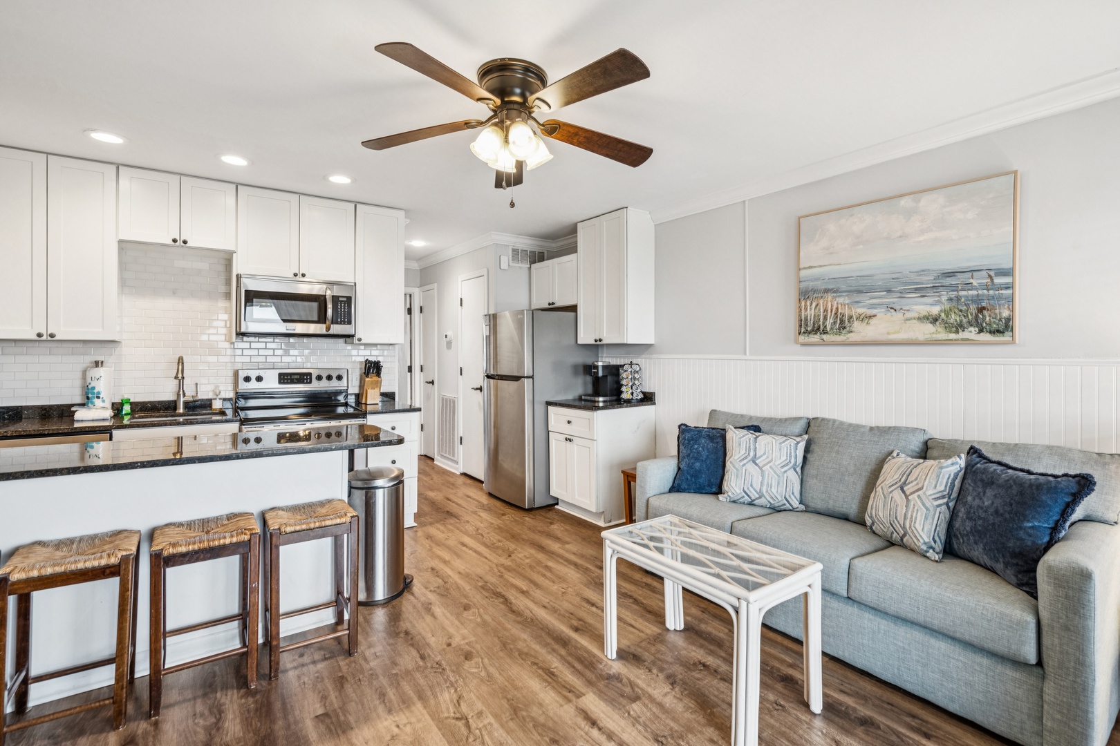 Relax in your open-concept space where the fully equipped kitchen flows into your cozy living area, complete with coastal artwork.