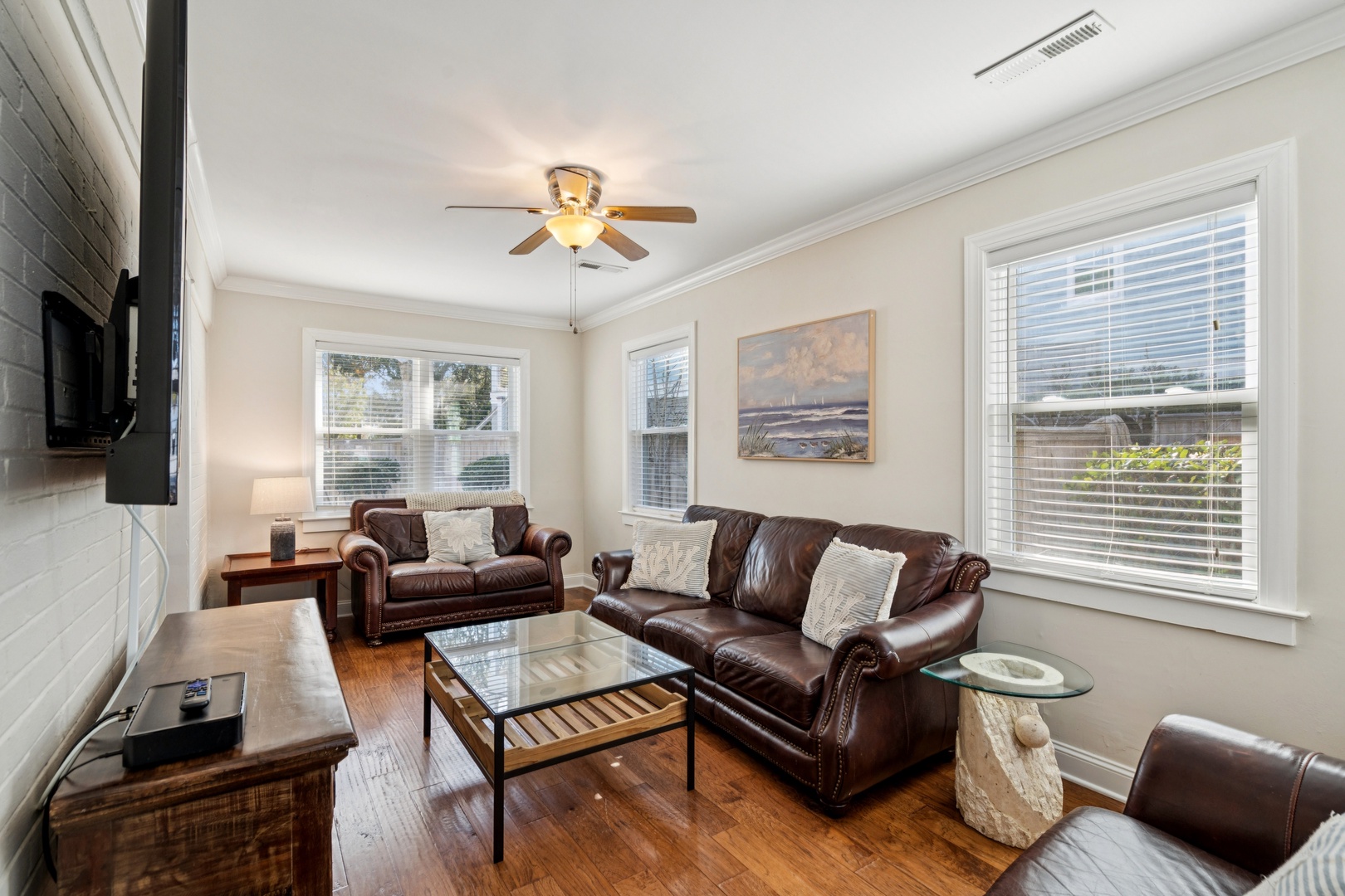 Unwind in your elegant living room where rich leather seating and warm wood floors create the perfect space for evening relaxation.