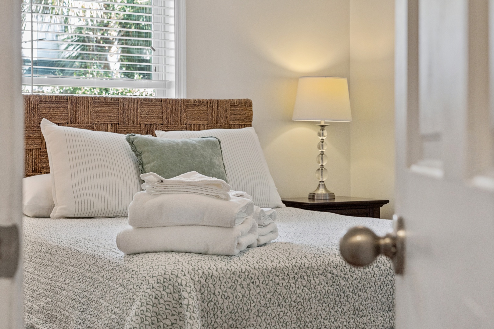Sink into your comfortable bed with crisp linens and fluffy towels awaiting your arrival in this peaceful, sunlit bedroom.