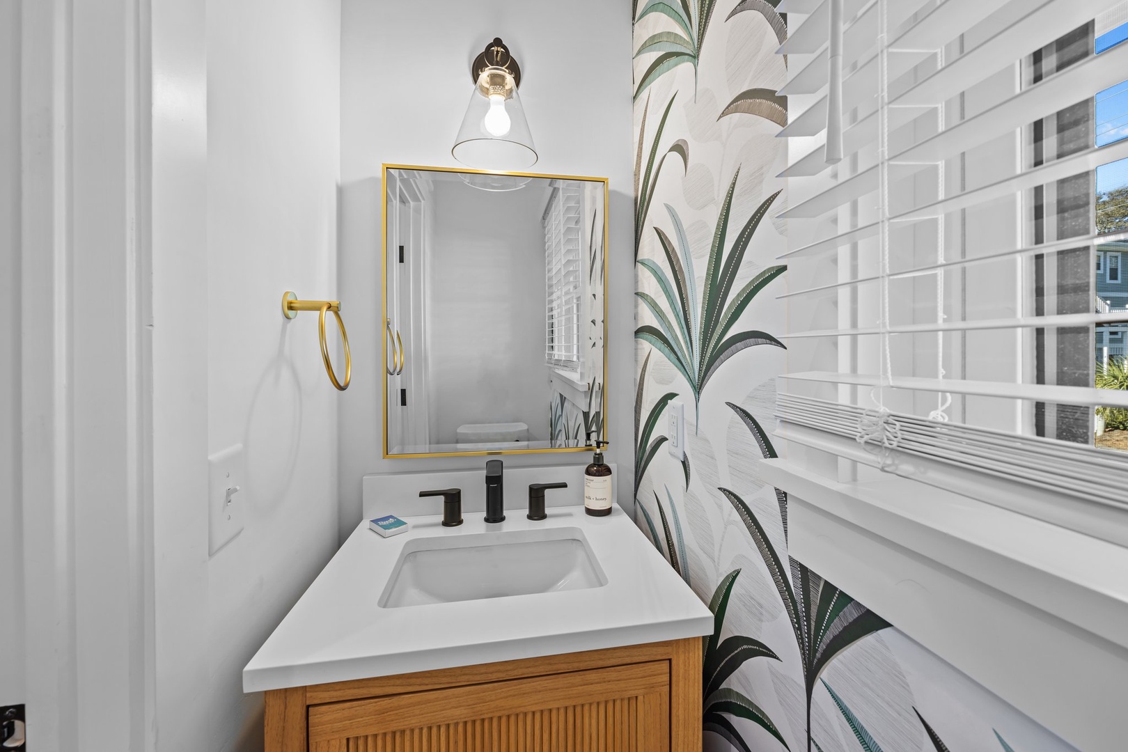 Step into your stylish bathroom featuring modern brass fixtures, subway tile, and natural light streaming through the window for a bright, welcoming space.