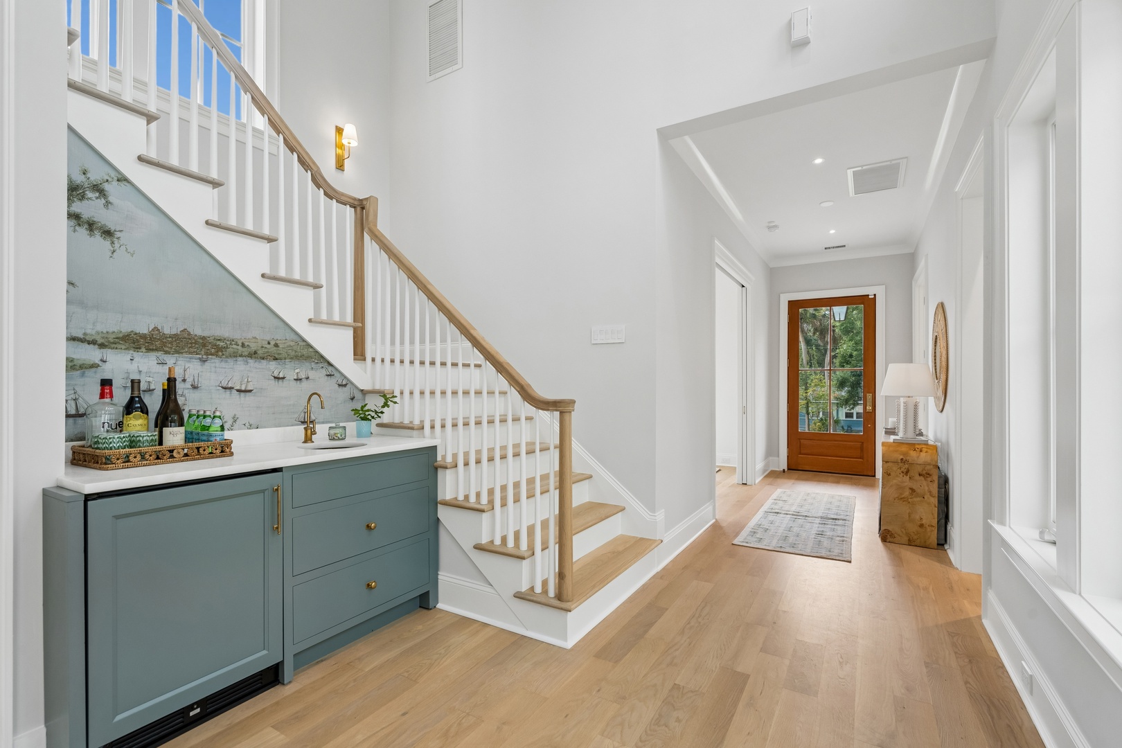 Step into your elegant entryway where natural light pours through gleaming windows and warm hardwood floors lead you home. A thoughtfully designed bar area invites you to mix your favorite drink after a day of adventure.