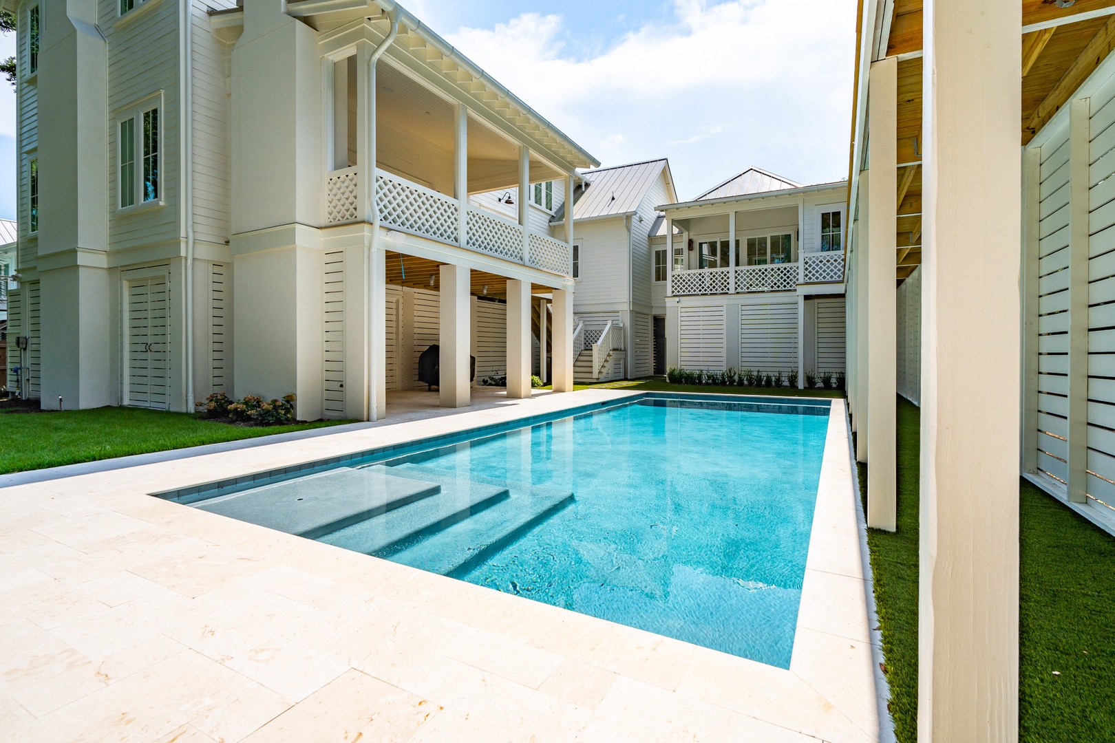 A private oasis awaits in your enclosed courtyard, where the sparkling pool invites you to cool off under the Florida sun. Slip into the crystal-clear water or lounge poolside surrounded by classic coastal architecture and lush green lawns.