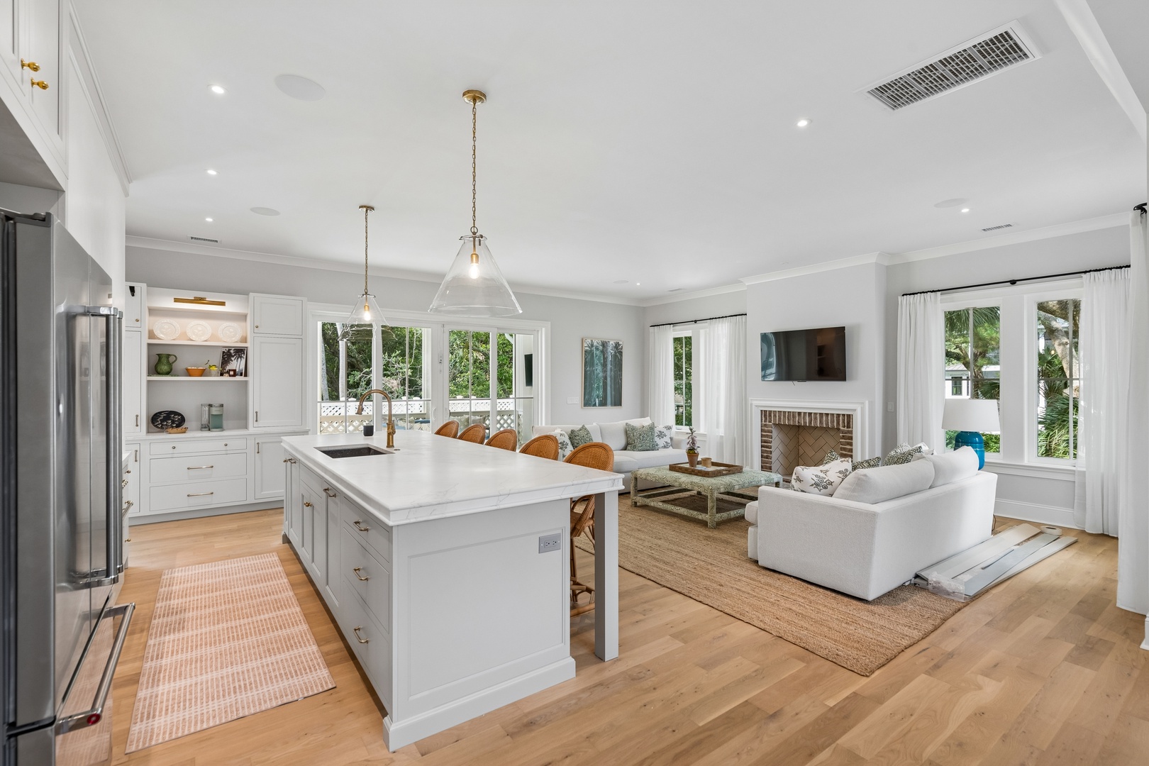 Step into your bright, open-concept living space where the kitchen flows seamlessly into the cozy lounge. Sunlight pours through tall windows, and you'll love unwinding by the fireplace.