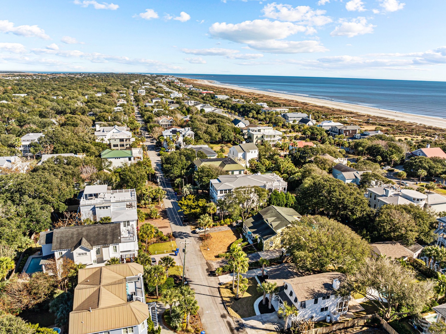Aerial view showcasing the coastal community with tree-lined streets and beautiful beach access nearby.