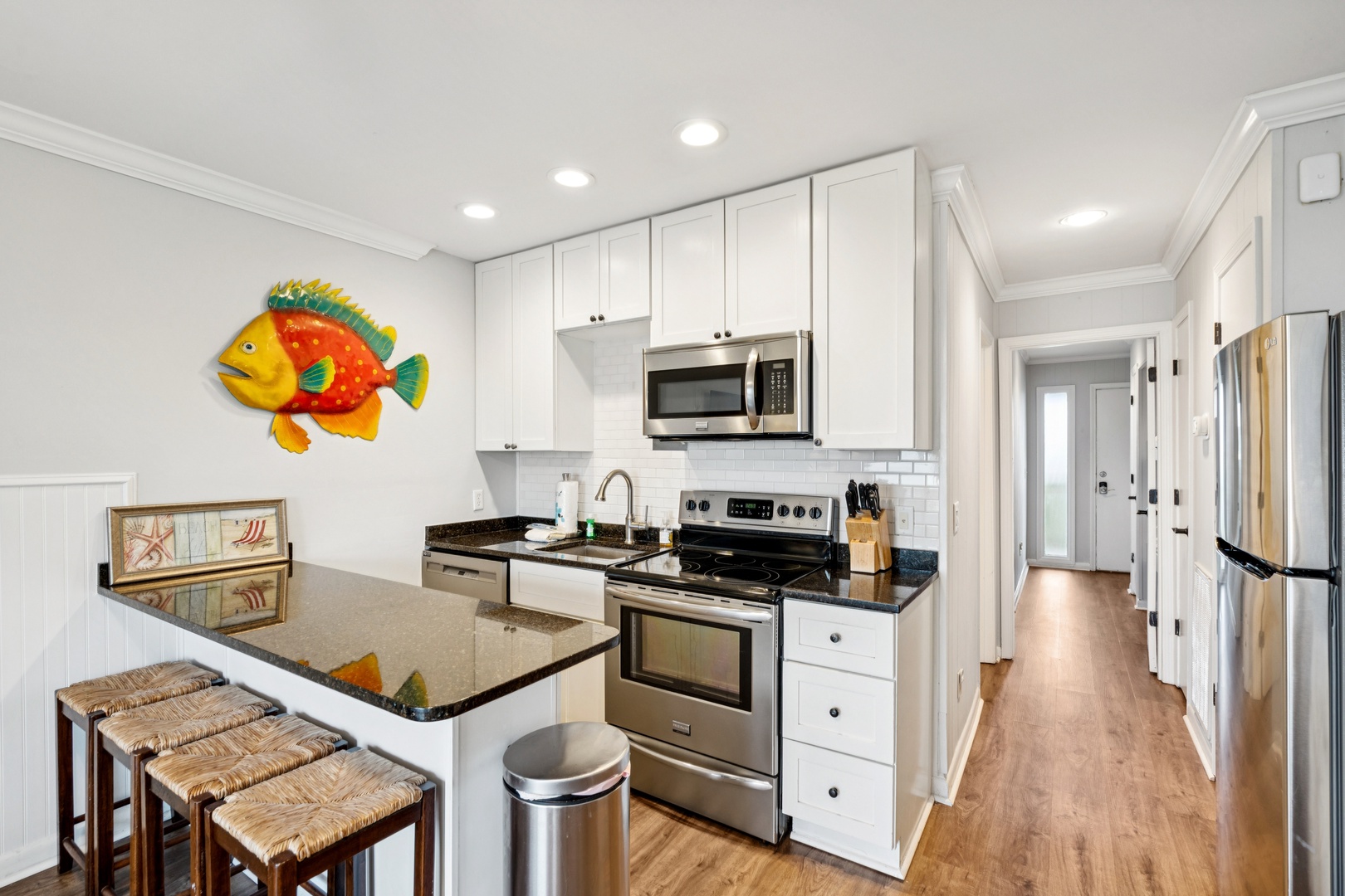 Your bright galley kitchen features modern stainless appliances, granite counters, and a convenient breakfast bar for casual dining.
