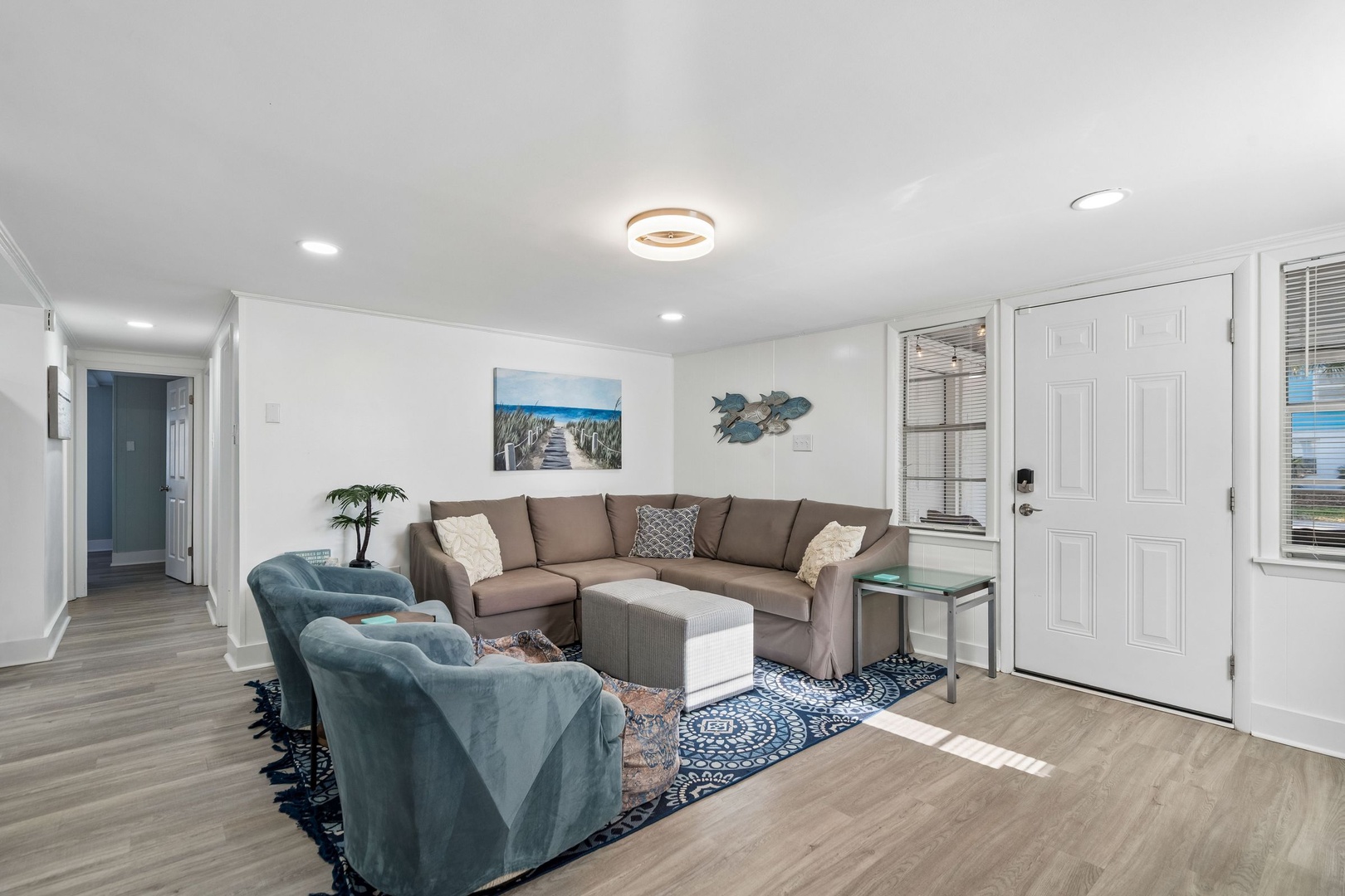 Settle into your bright, coastal-themed living space with plush sectional seating and ocean-inspired artwork welcoming you home.