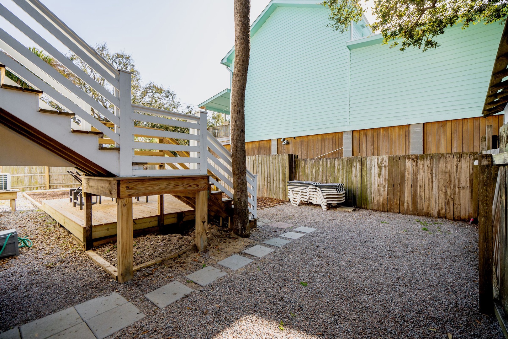 Charming outdoor courtyard with gravel pathways and wooden deck, perfect for your morning coffee or evening relaxation.