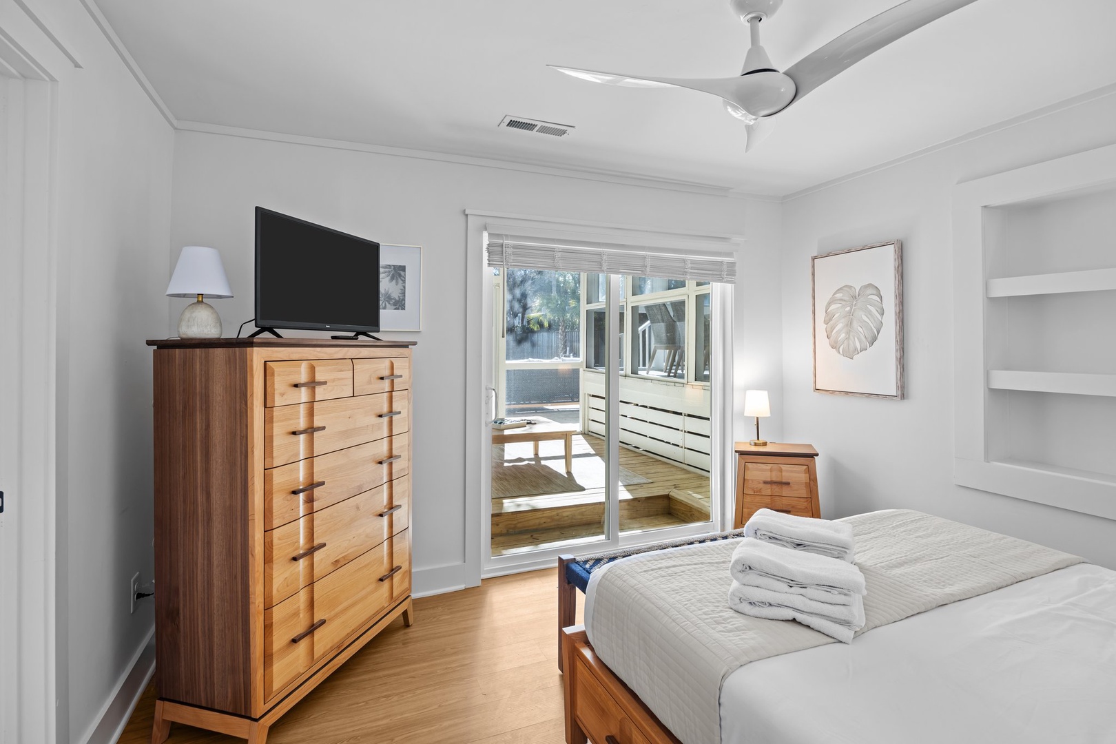 Your peaceful bedroom features warm wood furnishings, a ceiling fan for comfort, and sliding doors to your private outdoor space.