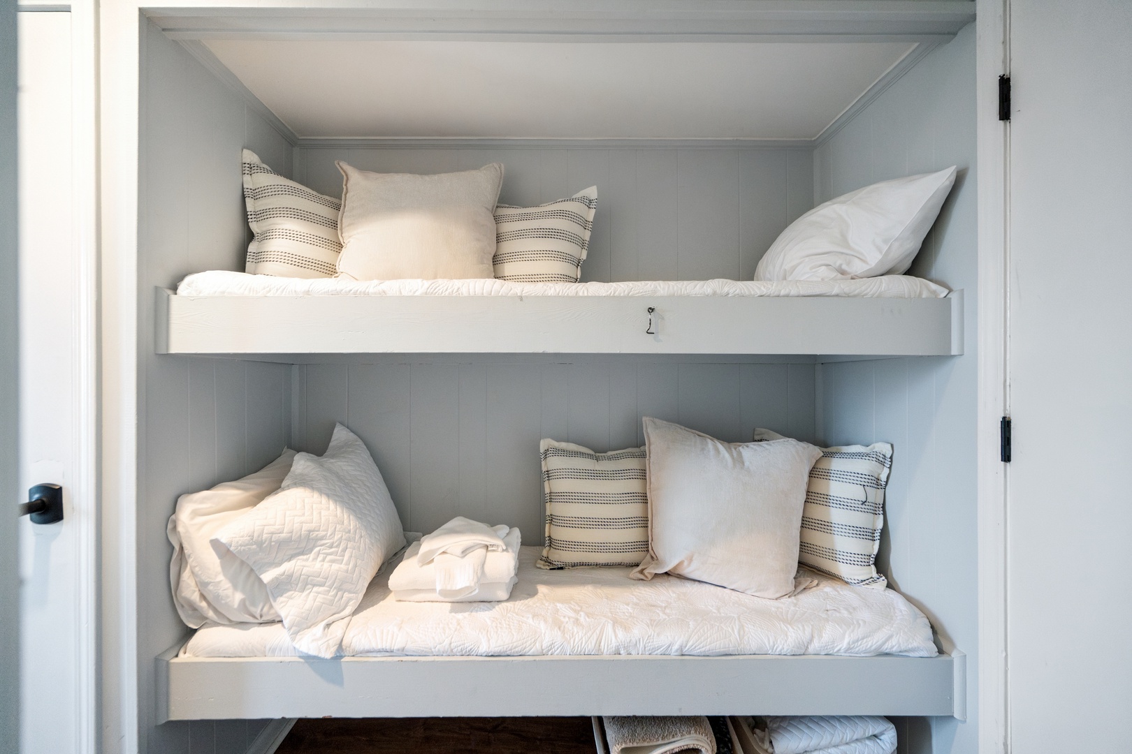 Drift off in your cozy built-in bunk beds with soft linens and striped accent pillows.