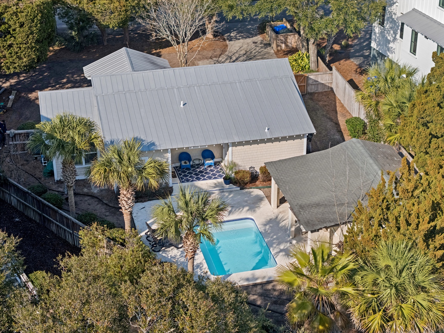A coastal vacation home featuring a private pool surrounded by tropical palm trees in a peaceful residential neighborhood.
