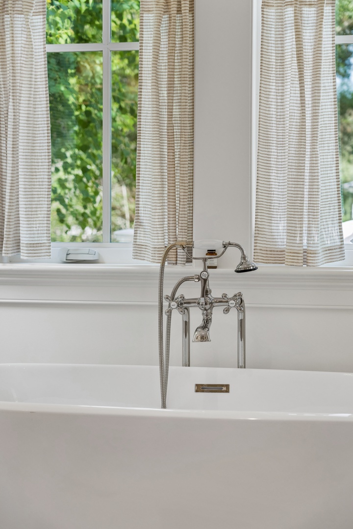 Slip into your private soaking tub and let the day melt away while sunlight filters through soft curtains and greenery whispers just beyond the window.