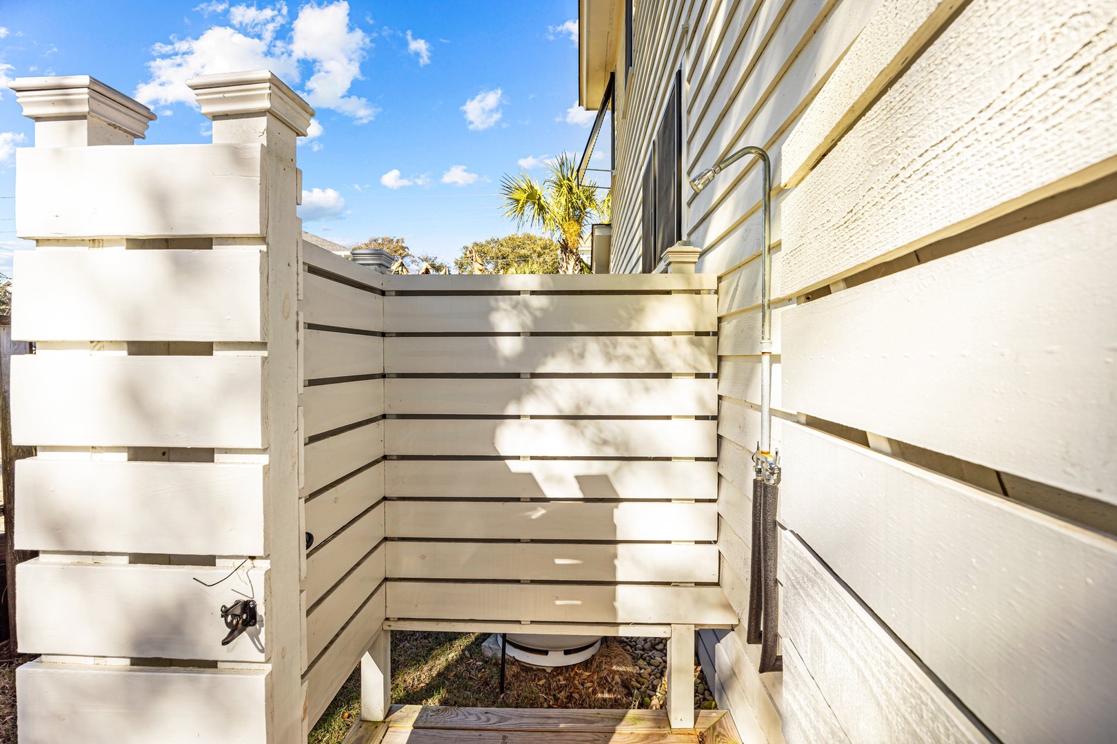 Bright modern staircase with clean lines leads to your private retreat, framed by blue skies and tropical palms.