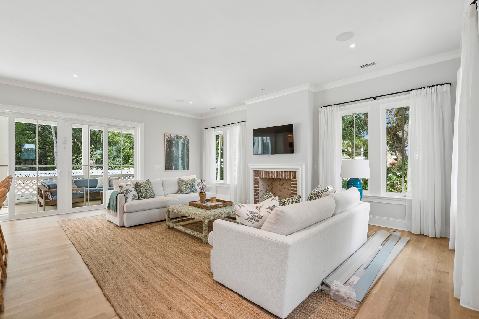 Sink into soft sofas and let the tropical greenery outside draw your eye through bright windows. A beautifully designed space where modern comfort meets coastal charm.