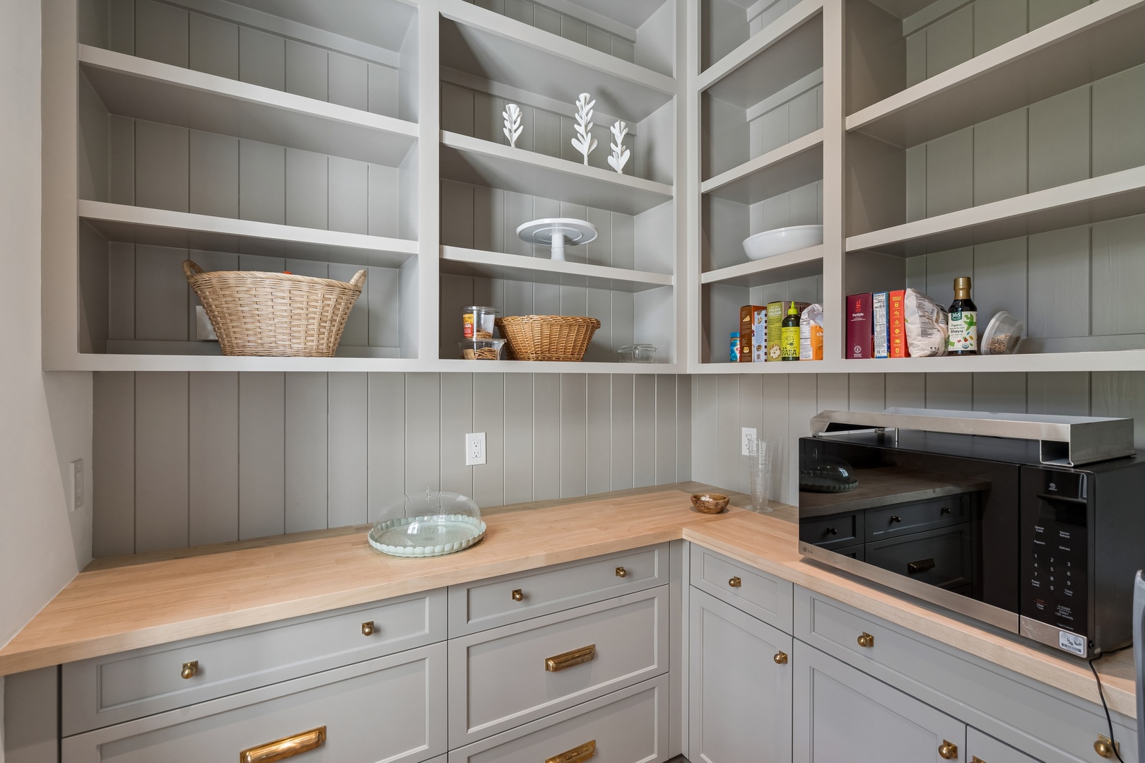 Your private pantry keeps everything organized and within reach, with open shelving for cookbooks and essentials, plus a handy microwave for quick meals.