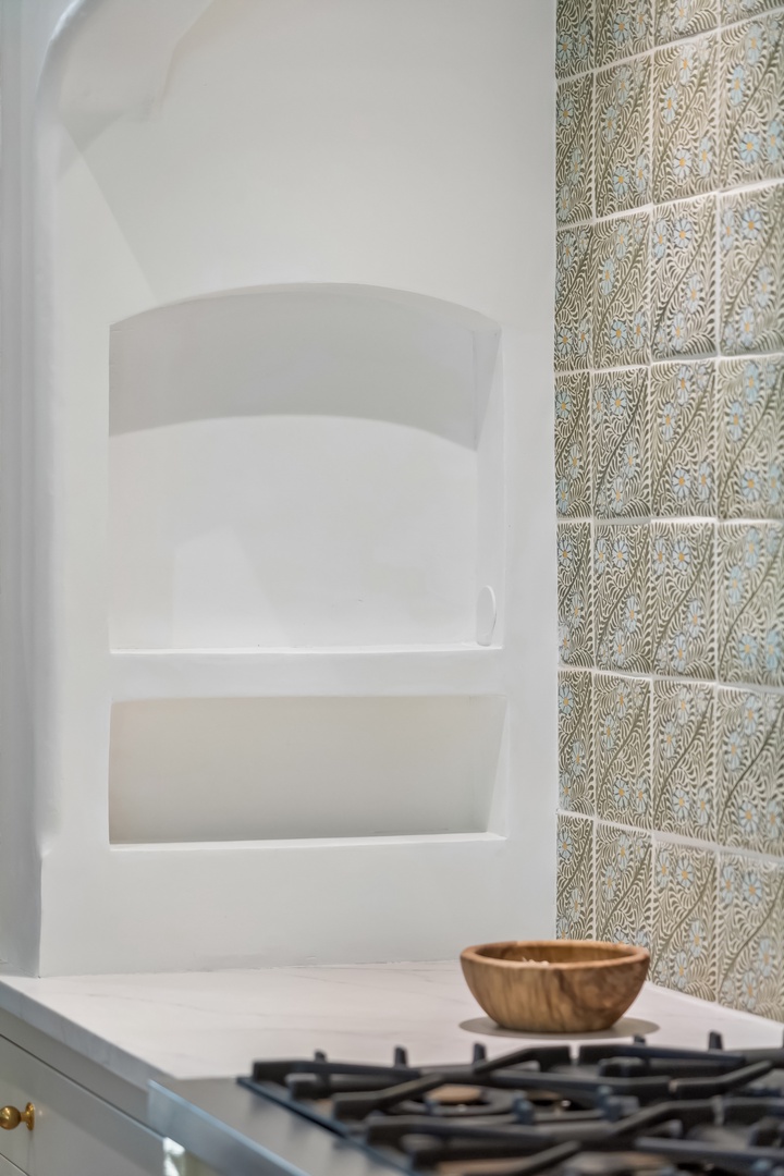 Your kitchen blends modern convenience with timeless charm—a sleek gas stove ready for home-cooked meals and elegant tiled backsplash adding warmth and character.