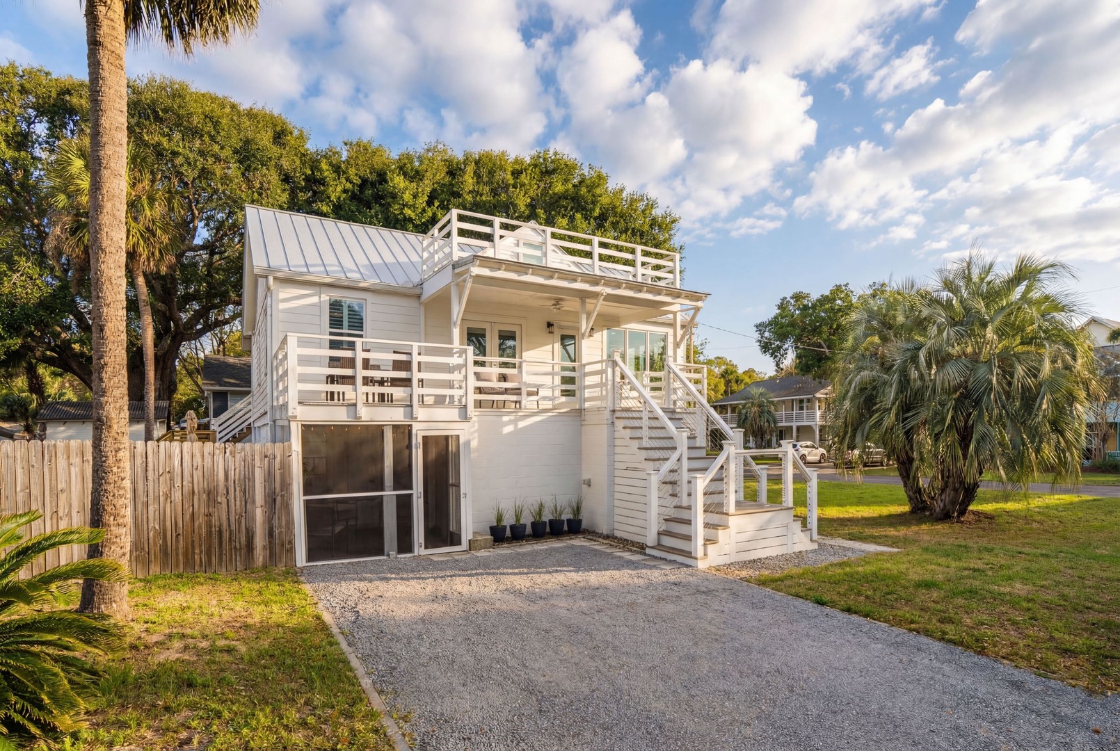 Modern coastal cottage with tropical landscaping and convenient parking in a peaceful residential neighborhood.