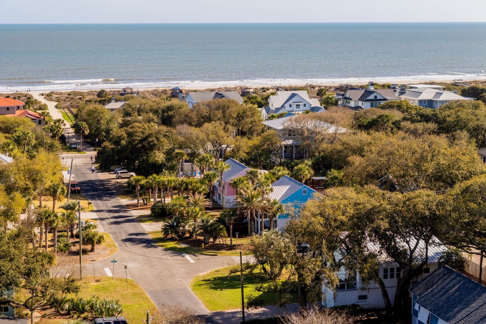 Charming coastal neighborhood just steps from pristine sandy beaches with colorful homes nestled among lush tropical vegetation.