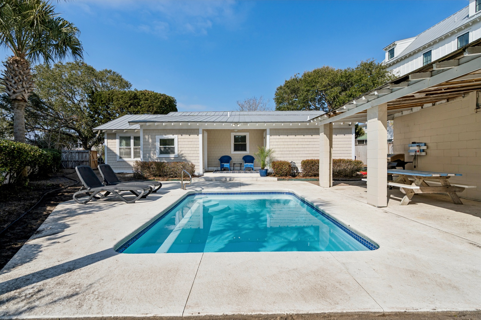Dive into your private oasis with a crystal-clear pool surrounded by comfortable loungers, all nestled in a peaceful backyard paradise.