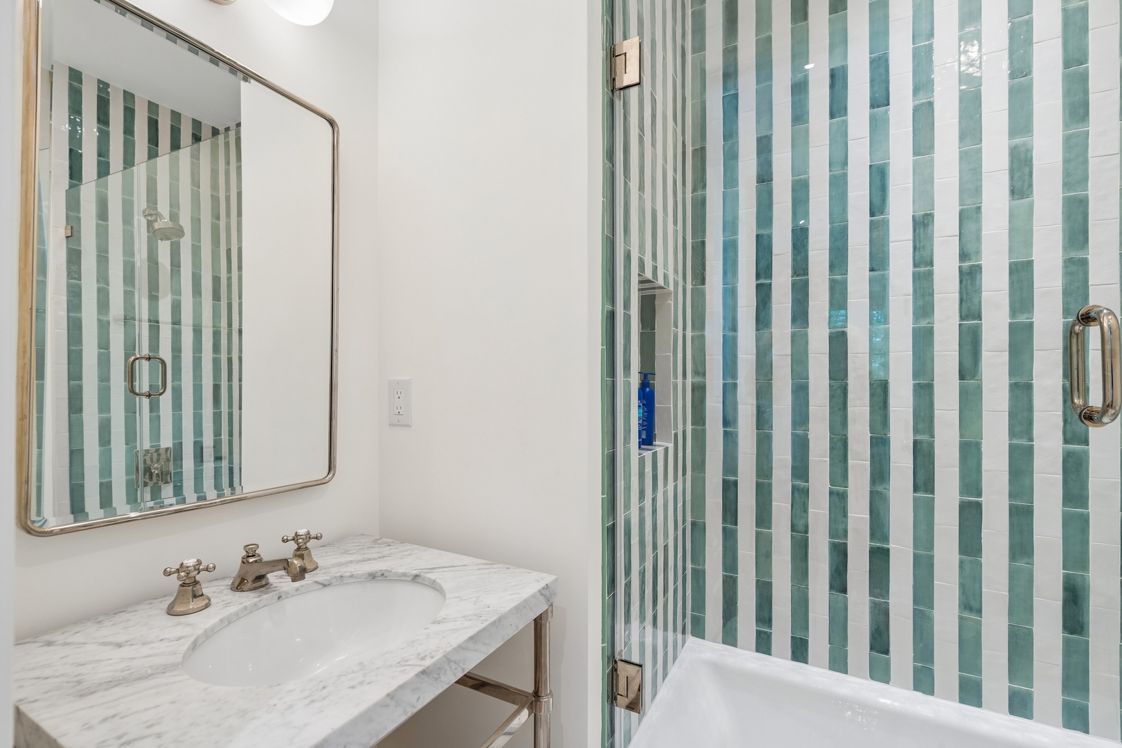 Step into this spa-like bathroom with soothing ocean-inspired tile and elegant marble finishes. You'll find a refreshing shower and peaceful space to unwind after your adventures.
