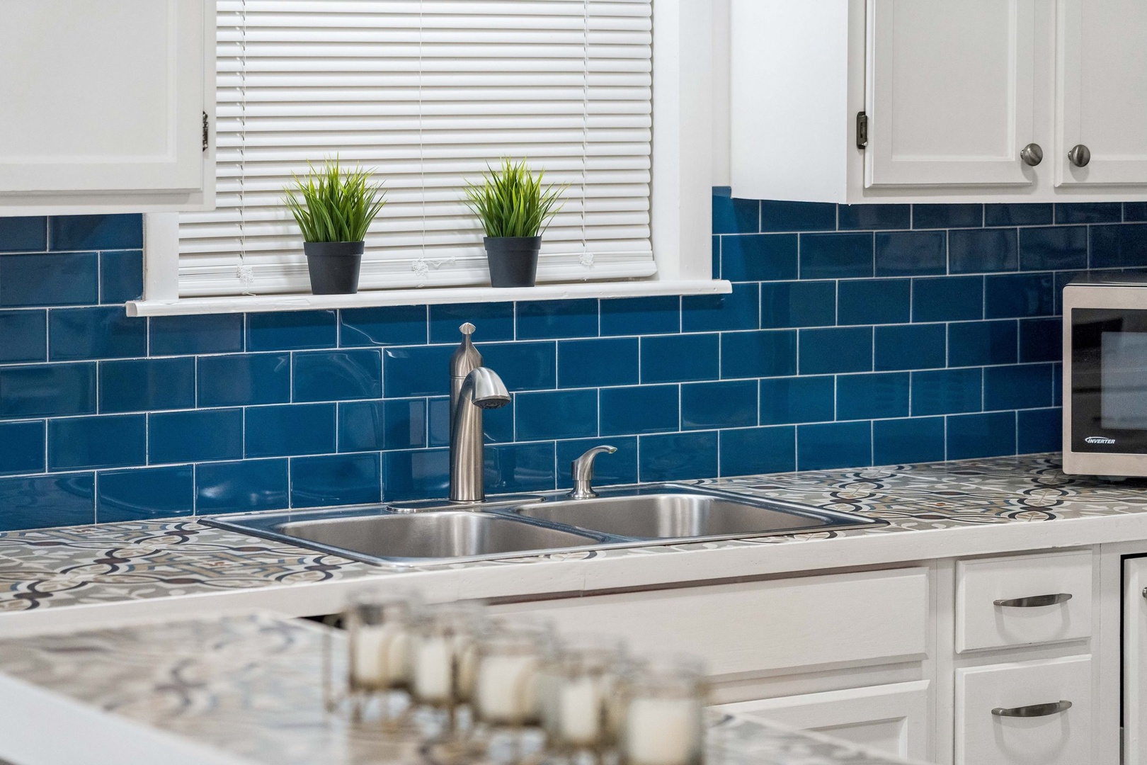 Your stylish kitchen features stunning blue subway tiles and modern appliances, perfect for preparing meals during your stay.