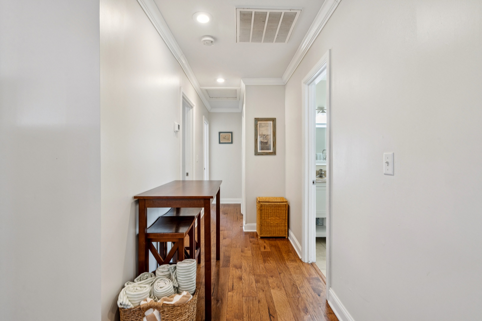 Step into your bright hallway where thoughtful touches like fresh towels and artwork make you feel instantly at home.