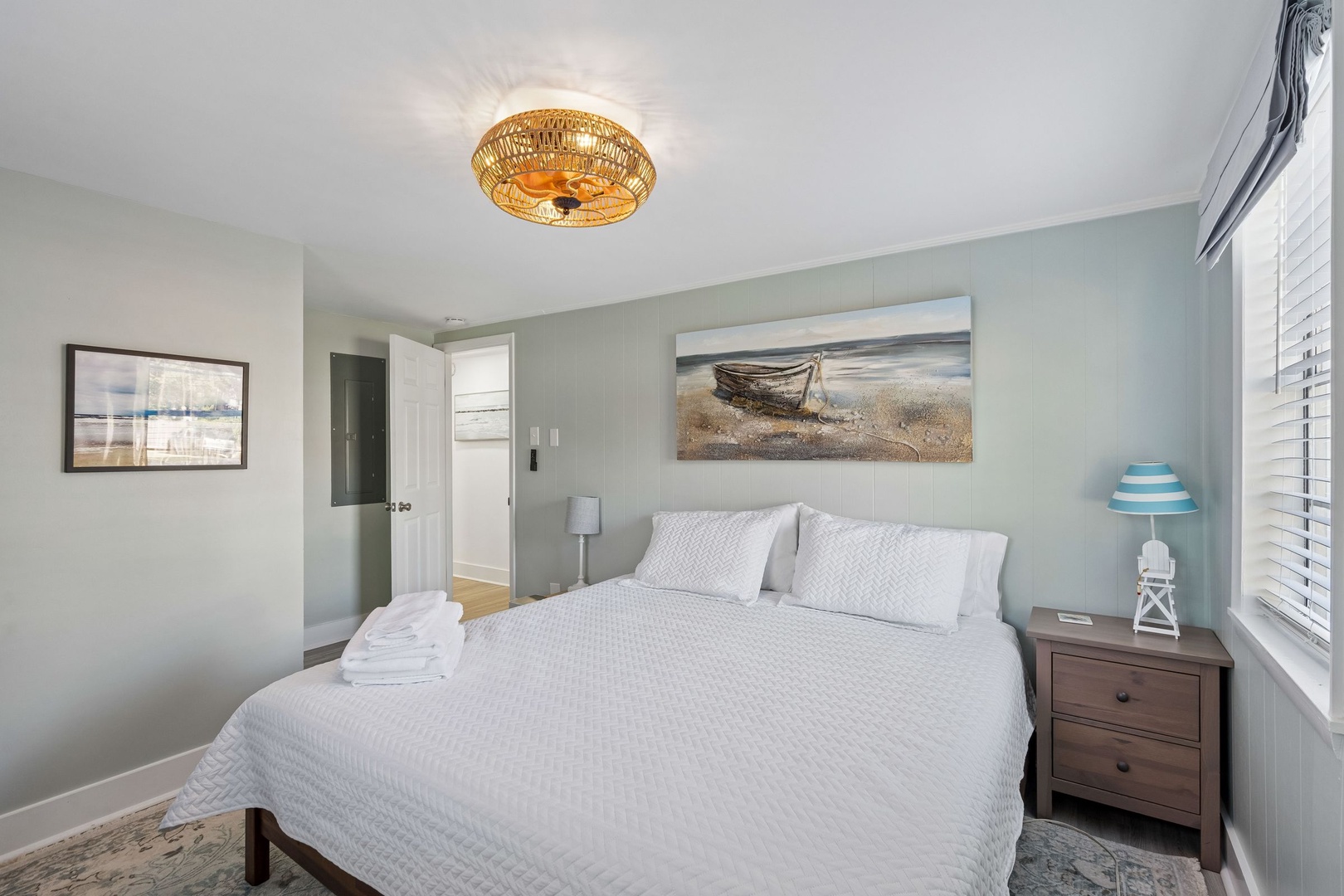 Your coastal retreat awaits with crisp white linens, nautical artwork, and warm amber lighting creating the perfect seaside sanctuary for restful nights.