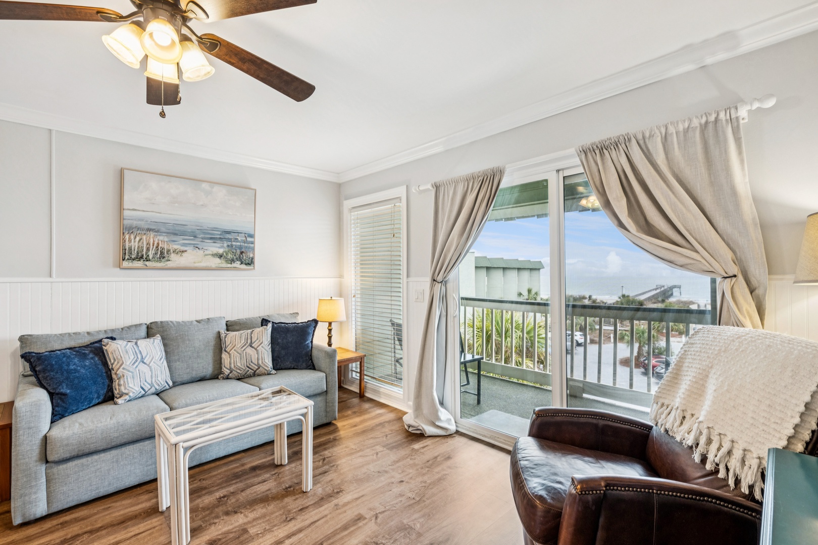Sink into coastal comfort in your inviting living room, complete with ceiling fan and private balcony overlooking the neighborhood.