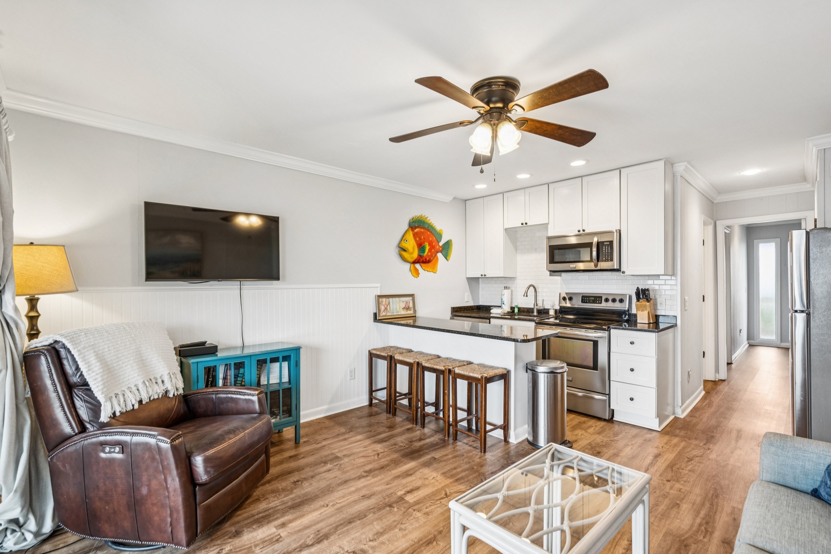 Your open-concept living space perfectly blends comfort and convenience with a full kitchen, cozy seating, and coastal charm.