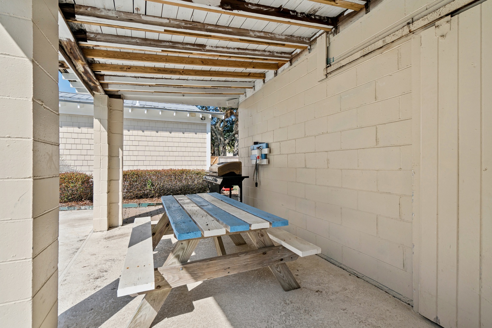 Your covered patio offers shade and comfort with a picnic table and BBQ grill for outdoor dining.