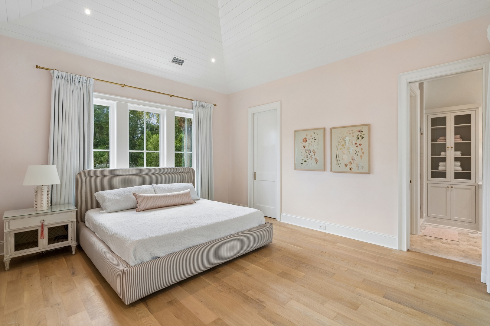 Sink into the plush comfort of your private bedroom, where soft natural light, serene blush tones, and warm wood floors create a peaceful retreat designed for restful nights.