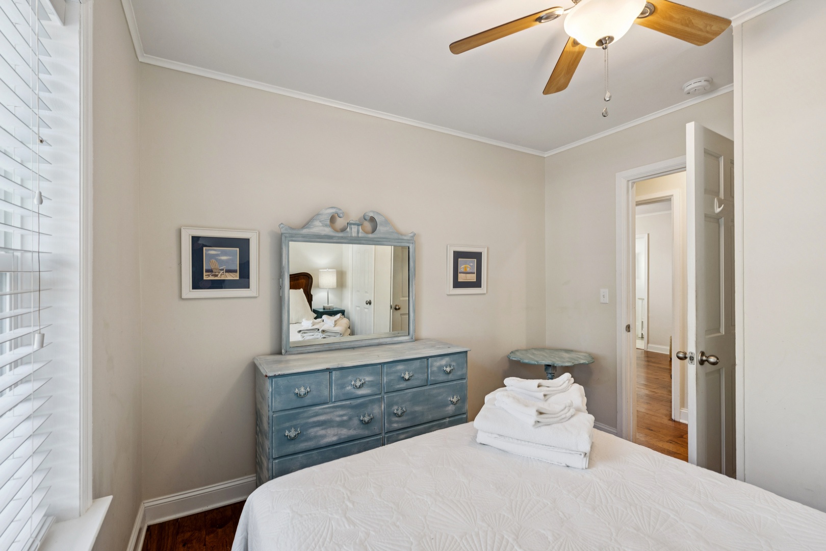 Rest peacefully in your serene bedroom featuring coastal-style furnishings, soft linens, and gentle ceiling fan breezes for ultimate comfort.